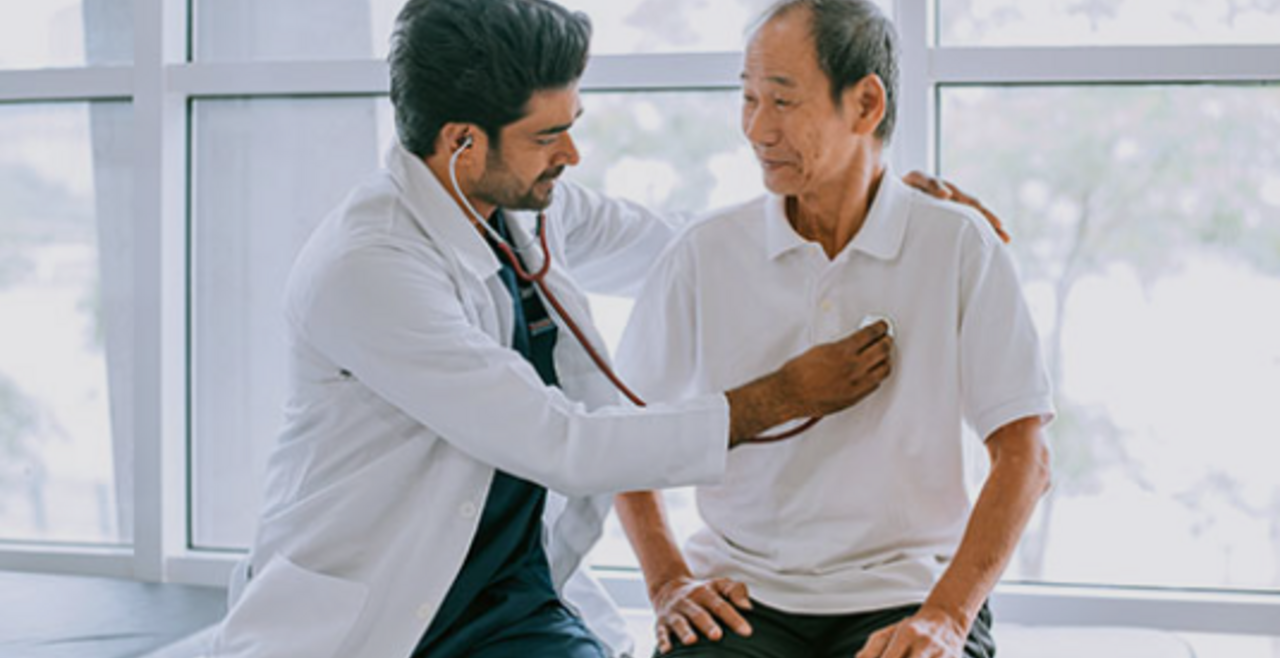 Doctor uses stethoscope to listen to an elderly individual’s heart